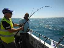 Neil Bryant admiring bend in the rod, Skipper Paul Whittall looks on